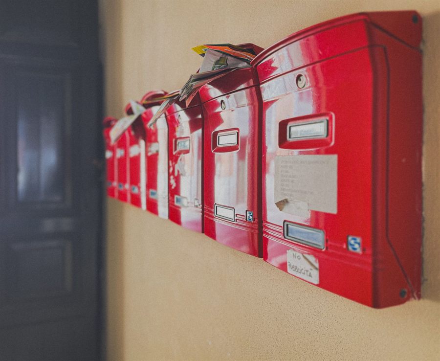 A row of red mailboxes fixed to a wall